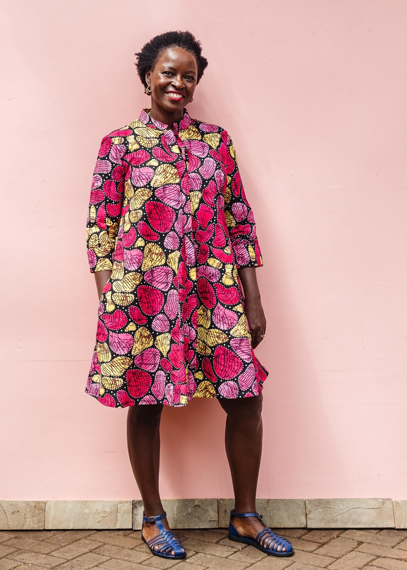 The model is wearing black, white, yellow, brown, pink, hot pink and purple bubble print dress