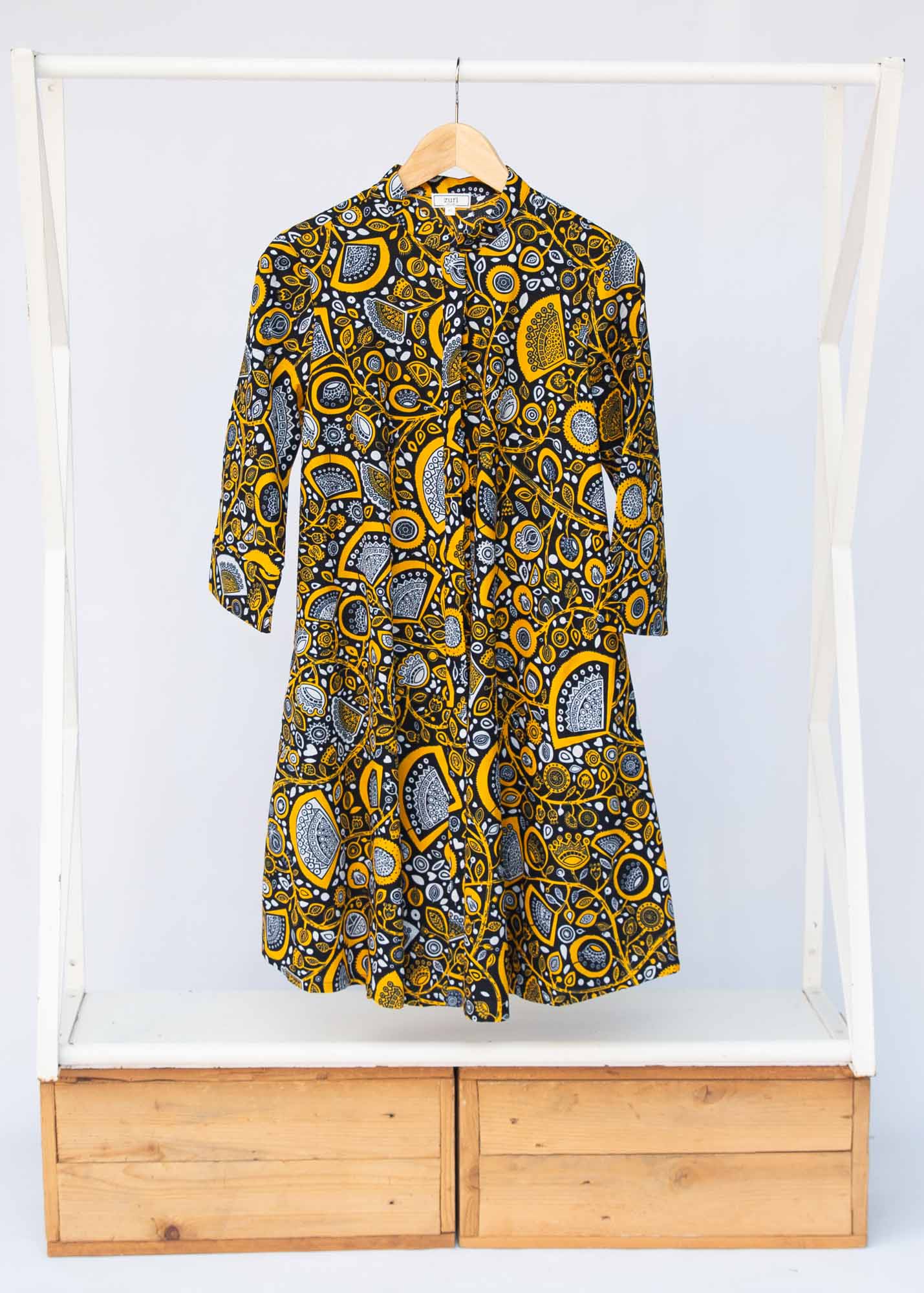 Display of black dress with white and yellow botanical print