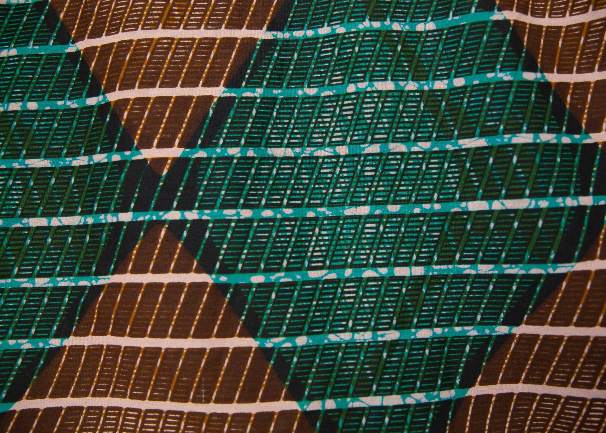 Close up display of  brown, camel, green and black diamond shaped geometric print shirt