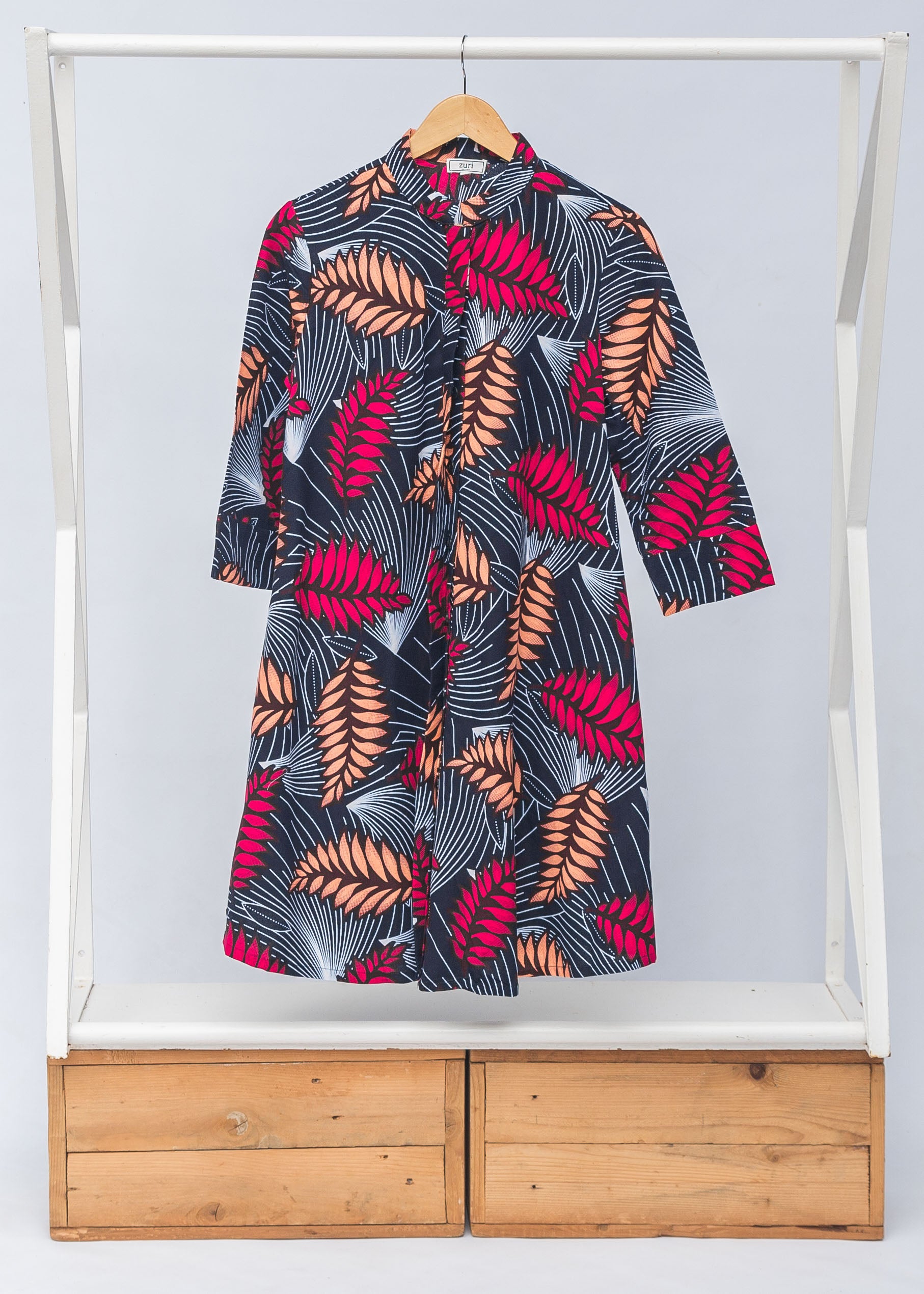 Display of navy dress with pink and peach feather print.