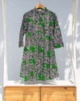 Display of white and black dress with green swirls.
