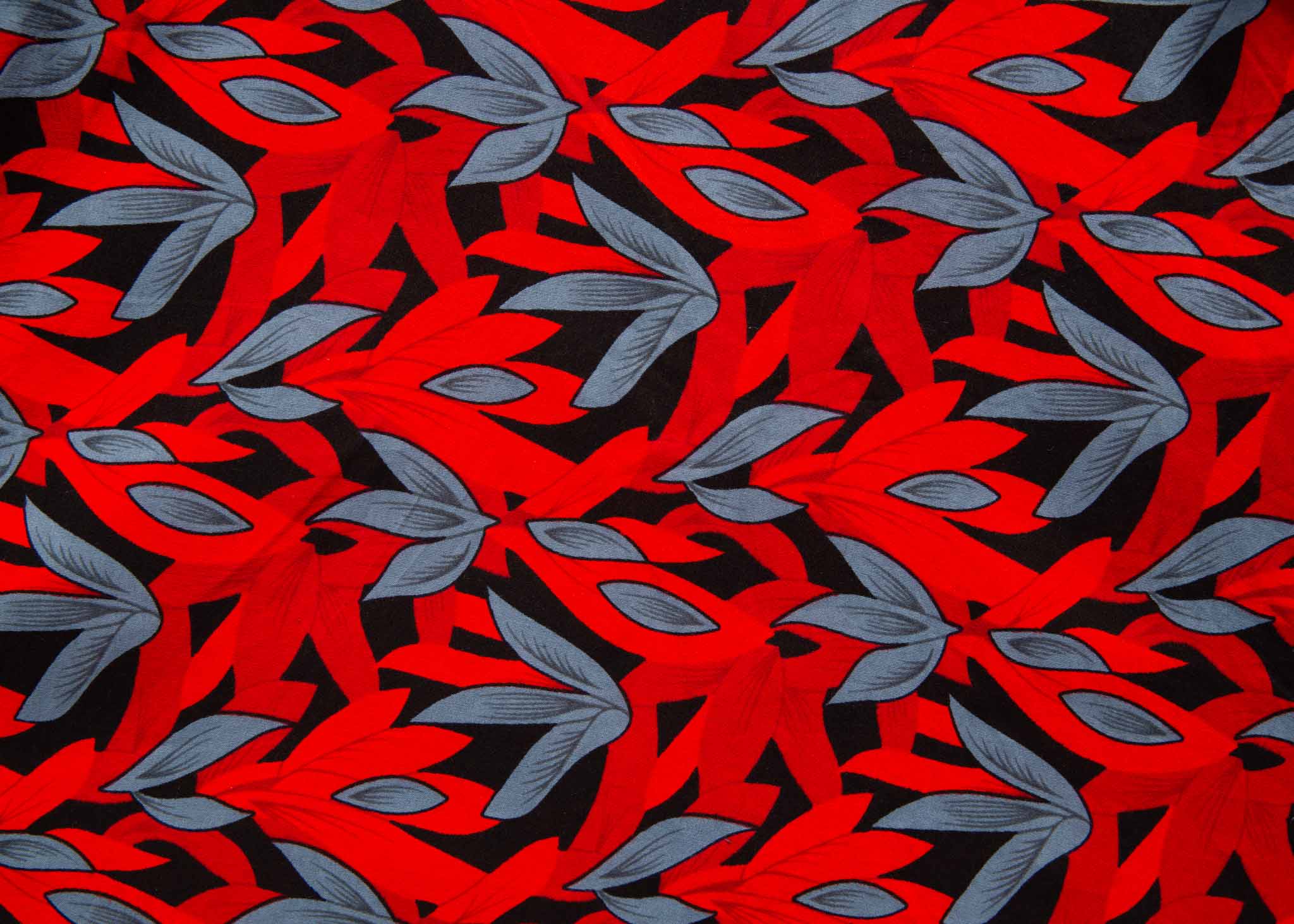 Close up display of red, black and gray leaf print dress, fabric.