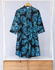Display of black dress with blue, white and turquoise peacock feather design print   