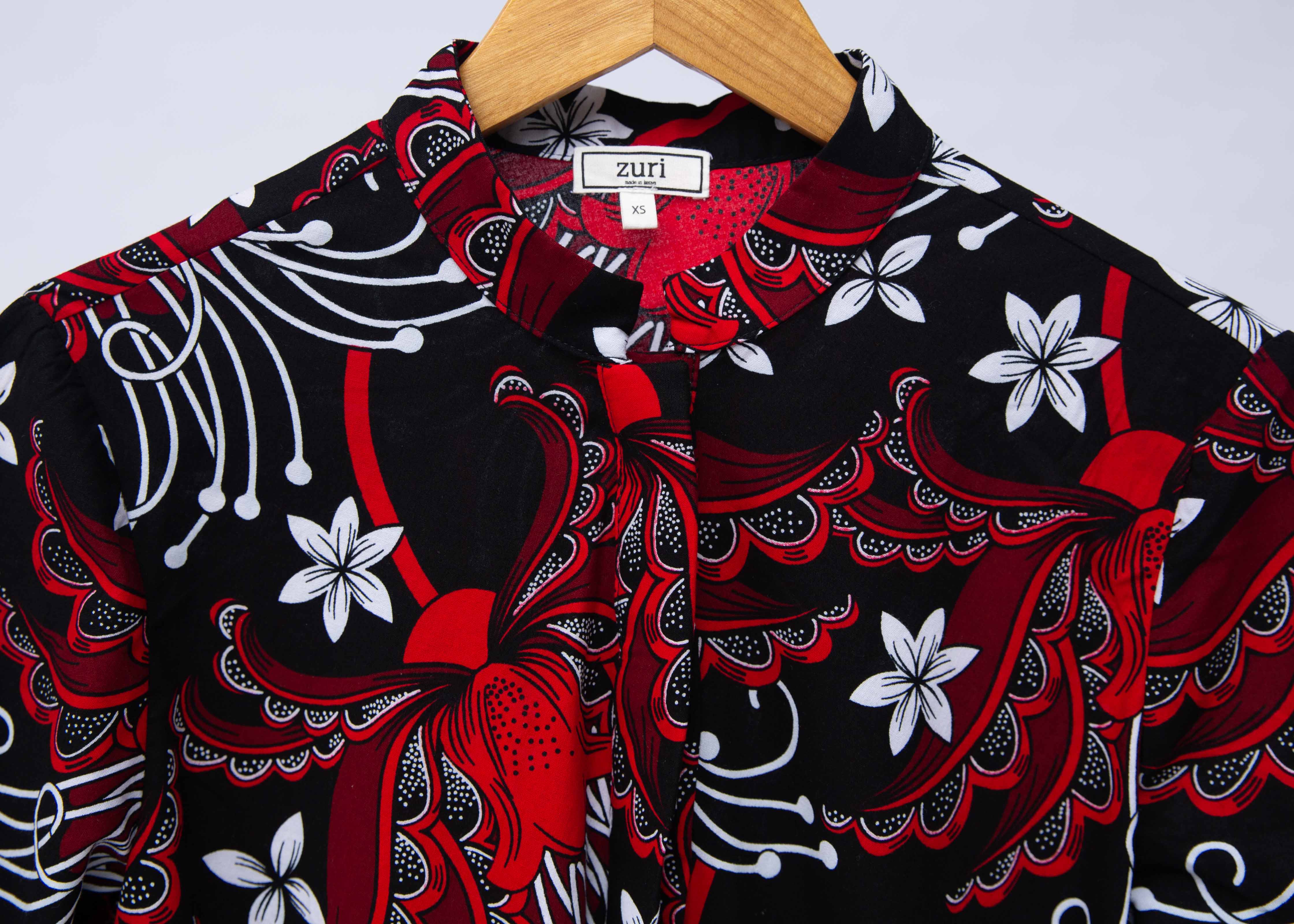 Display of black dress with red and white flowers.