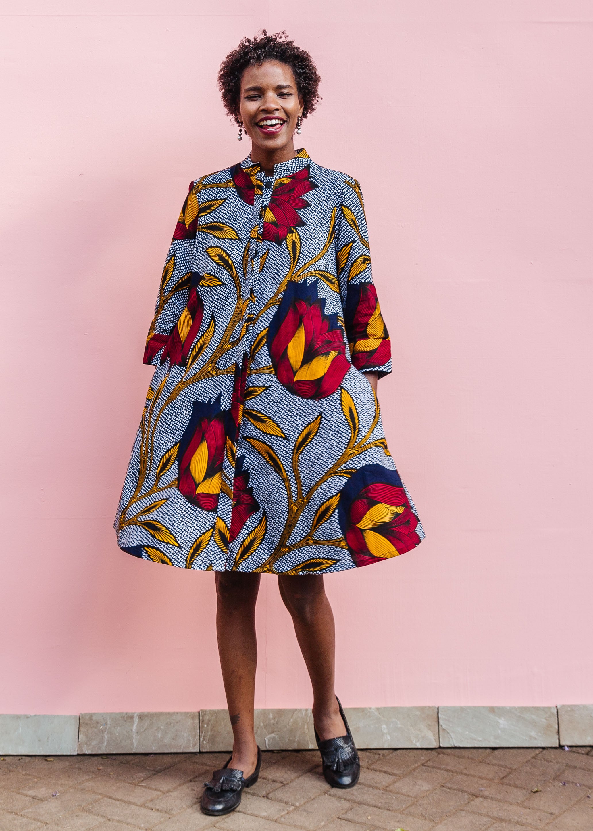 Model wearing red, yellow and navy flower print dress.