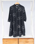 The display of solid black dress with white circular print