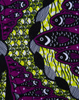 Close up display of yellow-green dress with purple, black, white fish print 