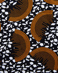 Close up Display of black and white dress with orange half circle print, fabric.