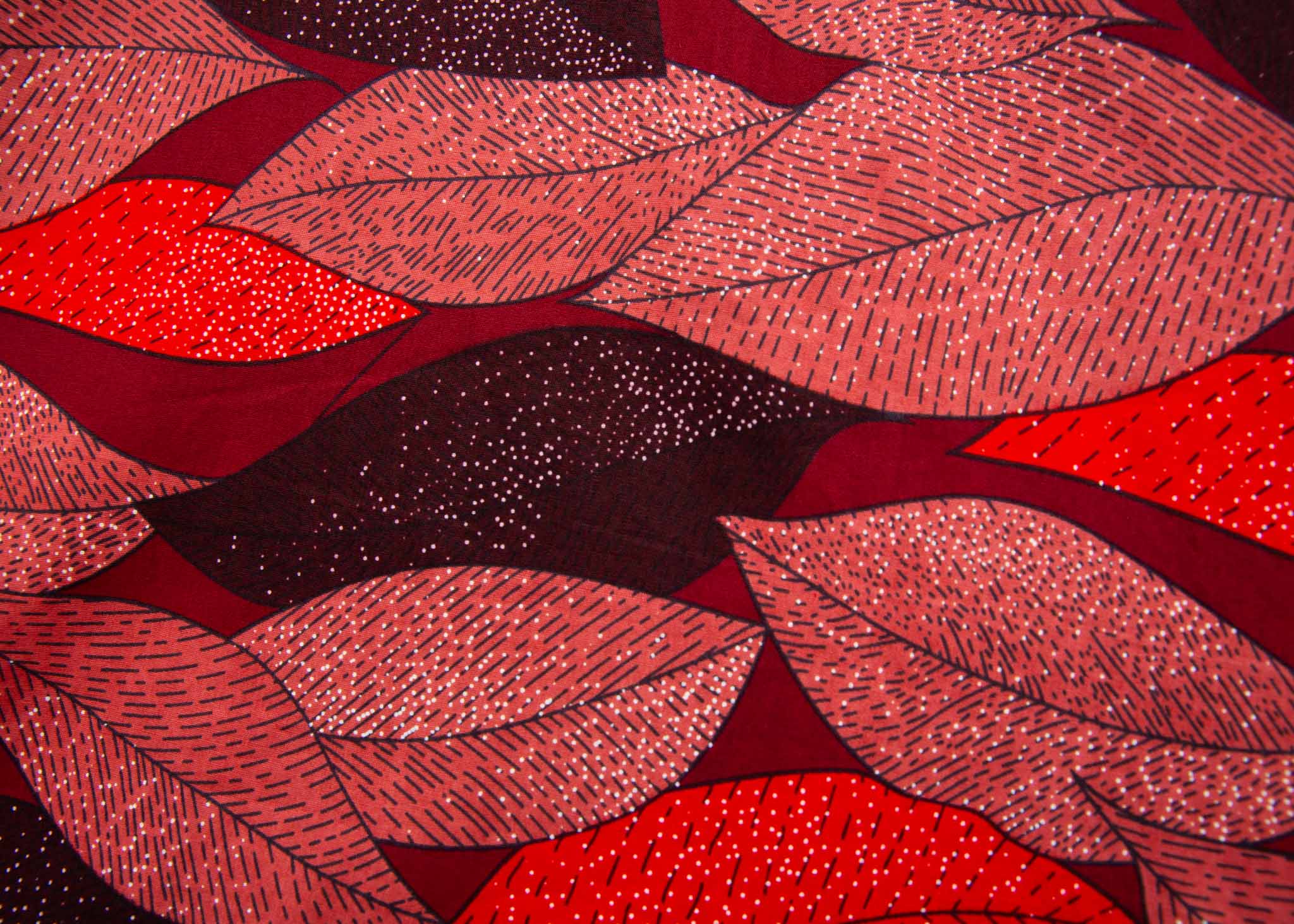 Close up display of red, brown, burgundy leaf print dress, fabric.