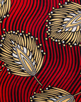 Close up display of red dress with brown feathers, fabric. 