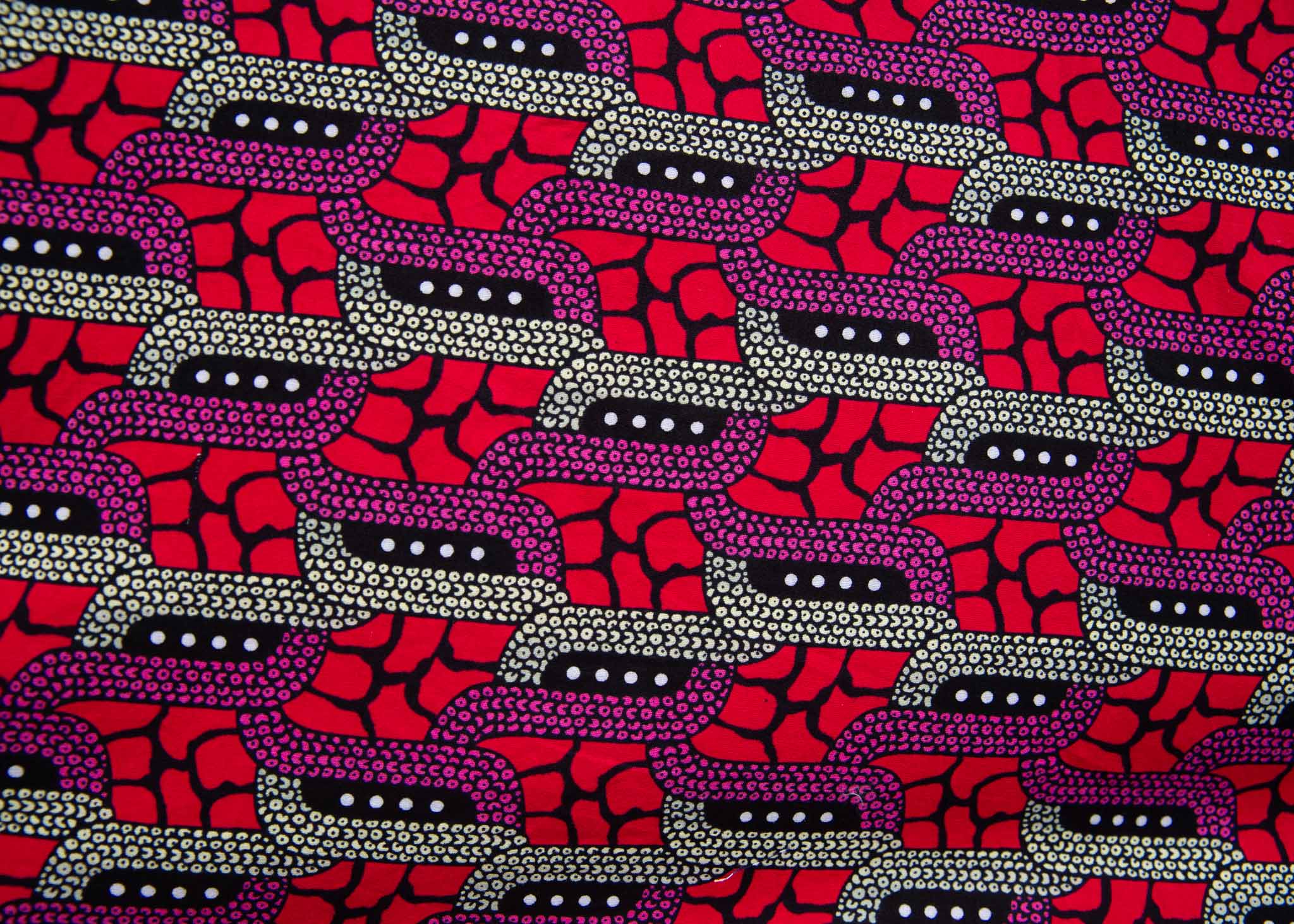Close up display of red and pink geometric print dress, fabric.