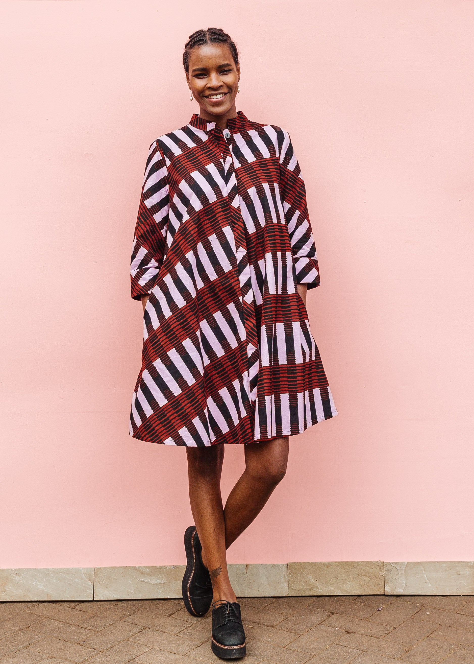 Model wearing pink and brown striped dress.