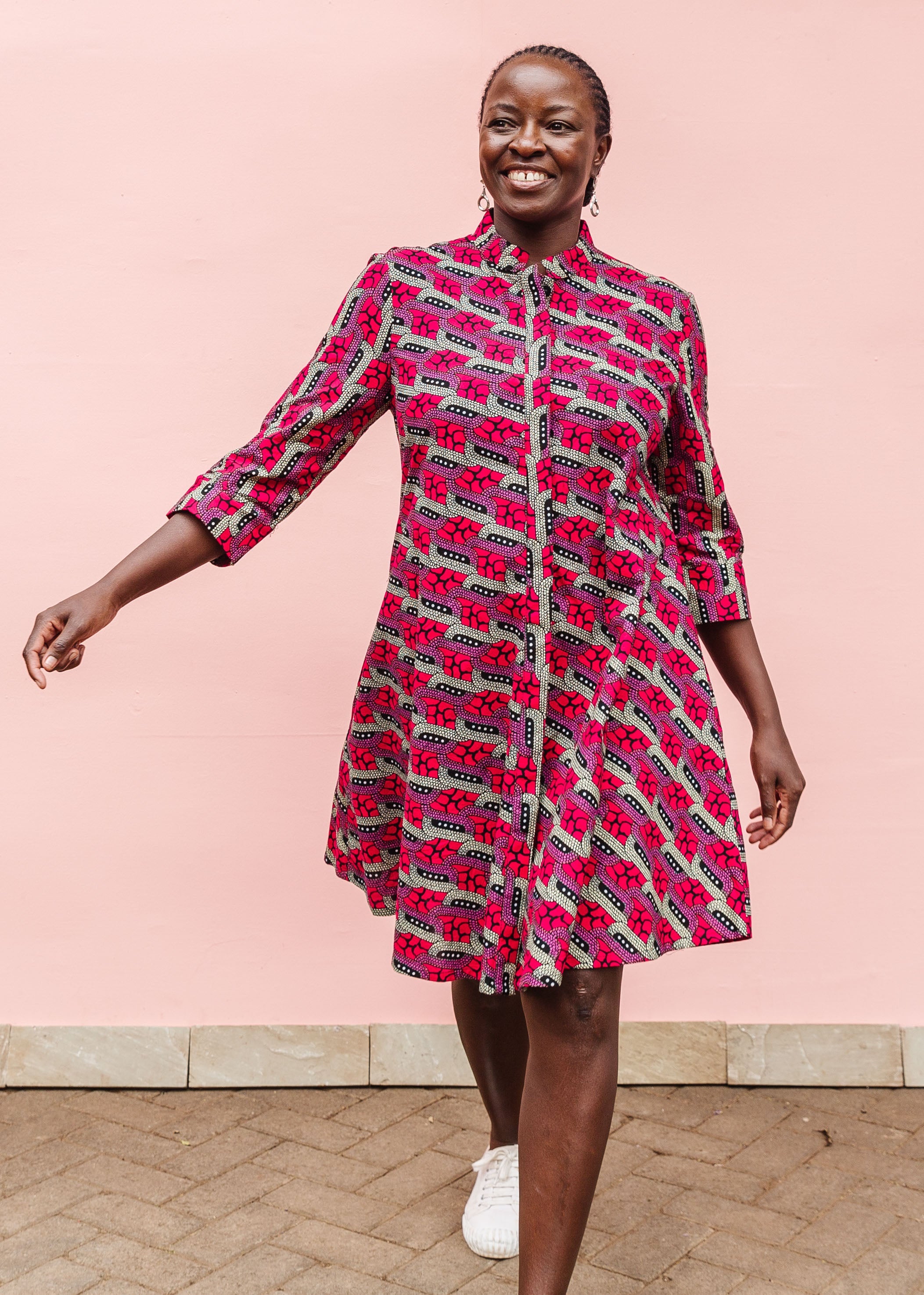 Model wearing red and pink geometric print dress.