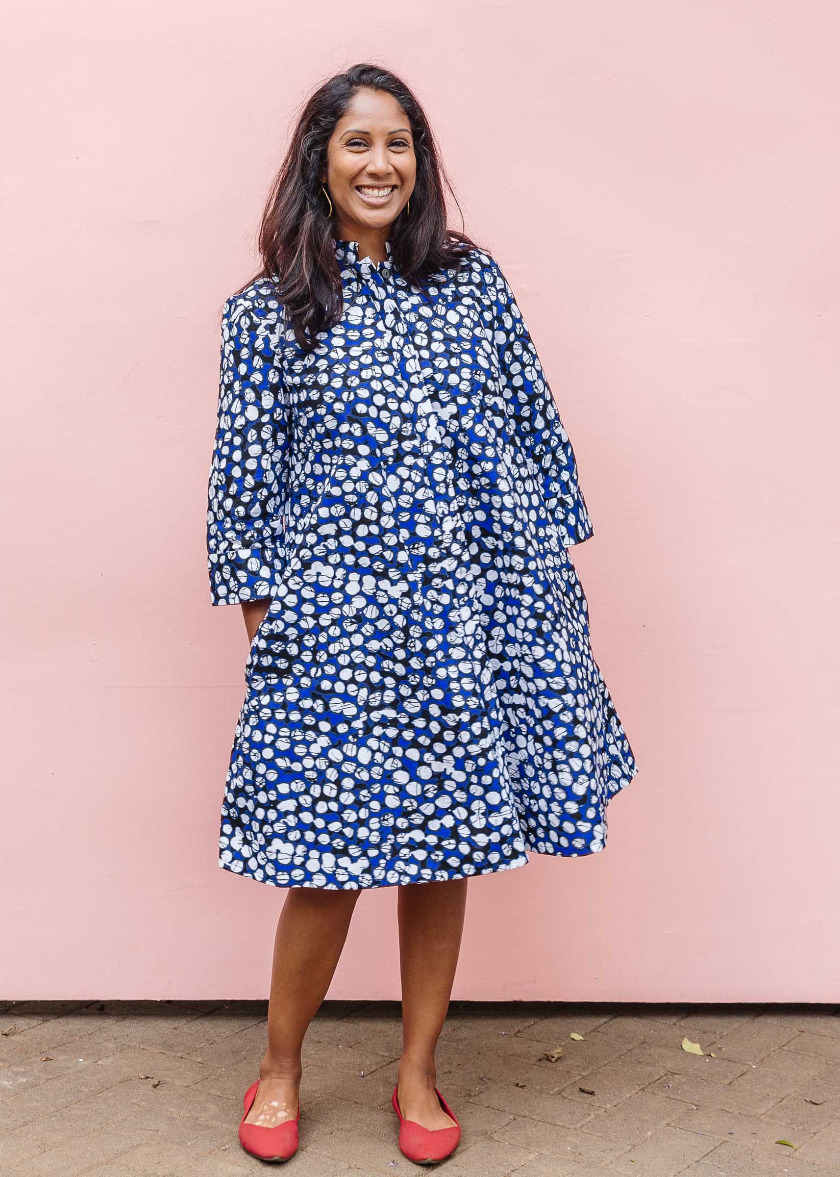 Model wearing blue dress with black and white abstract dots